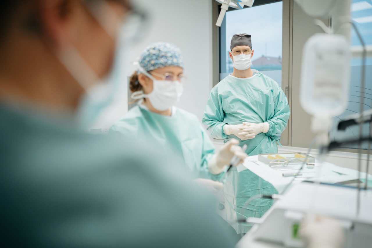 Dr. Dr. Sven Rieth gemeinsam mit einer Assistentin im OP-Raum.